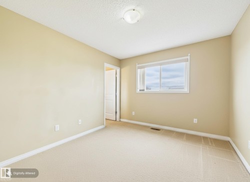 Bright room featuring a window with a view of the sky, light-colored carpet, and an open doorway - 9073 Scott Crescent, Edmonton, AB - Indoor Photo Showing Other Room