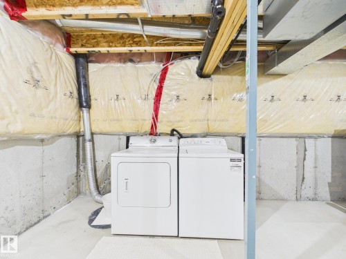 Laundry area featuring a washing machine and dryer, a concrete floor, and insulated walls - 9073 Scott Crescent, Edmonton, AB - Indoor Photo Showing Laundry Room