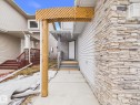 The property features a front entrance with a wooden trellis accent and stone siding, complemented by light-colored horizontal siding - 9073 Scott Crescent, Edmonton, AB  - Outdoor 