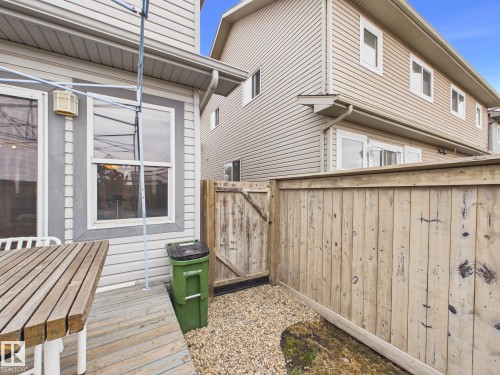 The property features a wooden deck area with a table, and windows providing natural light - 9073 Scott Crescent, Edmonton, AB - Outdoor With Exterior