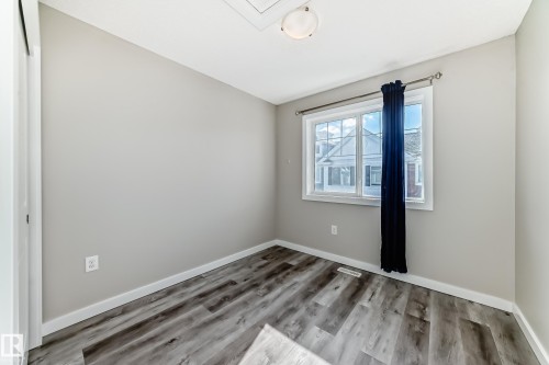 This room features light grey walls and multi-toned grey flooring - 75 2803 James Mowatt Trail, Edmonton, AB - Indoor Photo Showing Other Room