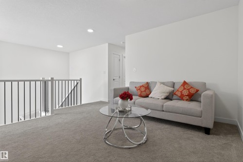 This versatile area features light gray carpeting, crisp white walls, and recessed lighting - 7344 177 Avenue, Edmonton, AB - Indoor Photo Showing Living Room