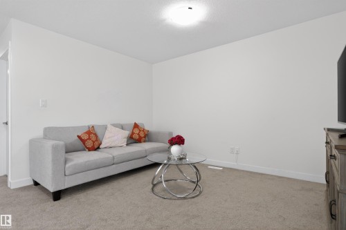 Inviting living area featuring light-colored carpeting, white walls, and a ceiling light fixture - 7344 177 Avenue, Edmonton, AB - Indoor Photo Showing Living Room