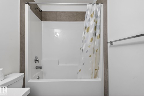 The bathroom features a clean white tub and shower combination with chrome fixtures - 7344 177 Avenue, Edmonton, AB - Indoor Photo Showing Bathroom