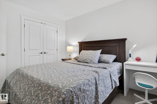 This room features white walls, a dark wood headboard, and a white desk - 7344 177 Avenue, Edmonton, AB - Indoor Photo Showing Bedroom