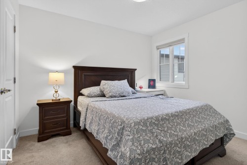This room features light-colored walls and carpeting, a window with trim, and a ceiling light fixture - 7344 177 Avenue, Edmonton, AB - Indoor Photo Showing Bedroom
