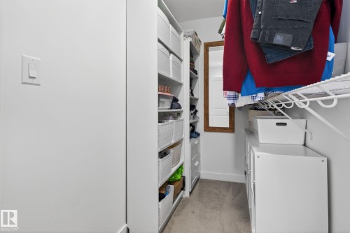The property features a walk-in closet with carpeted flooring, built-in shelving, and a wall-mounted mirror - 7344 177 Avenue, Edmonton, AB - 