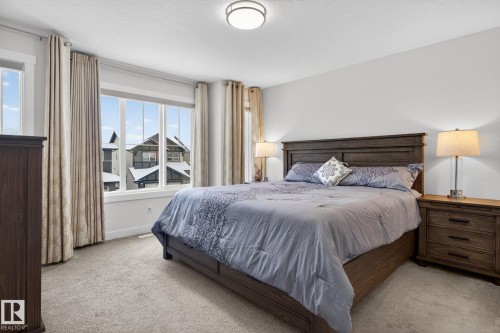 Inviting bedroom featuring ample natural light, soft carpeting, and window treatments - 7344 177 Avenue, Edmonton, AB - Indoor Photo Showing Bedroom