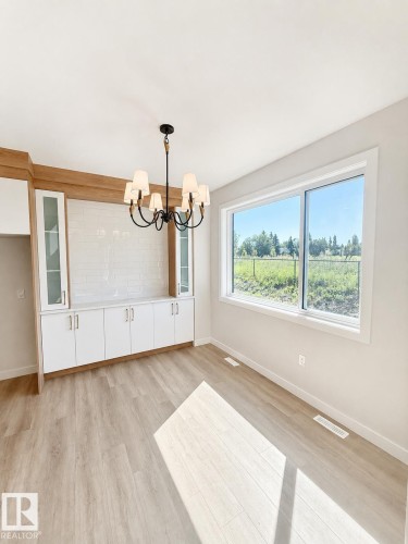 Built-in cabinetry with glass-front uppers and white subway tile backsplash - 22 Meadowgrove Landing, Spruce Grove, AB - Indoor Photo Showing Other Room
