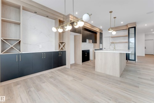 The kitchen and dining area features light-toned flooring, a kitchen island with a sink, and pendant lighting - 22 Meadowgrove Landing, Spruce Grove, AB - Indoor Photo Showing Kitchen With Upgraded Kitchen