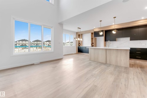The property features a spacious open-concept interior with light-toned flooring and high ceilings - 22 Meadowgrove Landing, Spruce Grove, AB - Indoor Photo Showing Kitchen