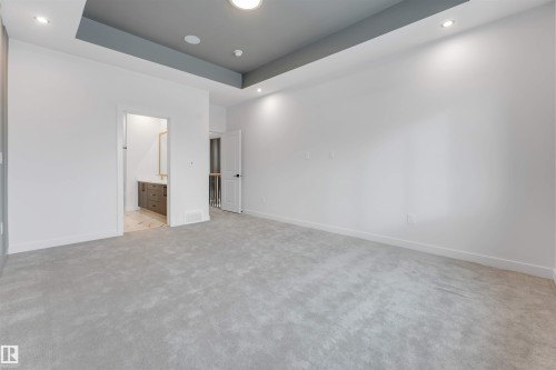 This spacious room features light grey carpeting, white walls, and a dropped ceiling with recessed lighting - 22 Meadowgrove Landing, Spruce Grove, AB - Indoor Photo Showing Other Room