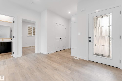 Entryway featuring light wood flooring, white walls, and a front door with decorative glass inserts - 22 Meadowgrove Landing, Spruce Grove, AB - Indoor Photo Showing Other Room