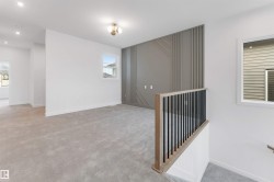 This room features light grey carpeting, recessed lighting, and a decorative accent wall with vertical and diagonal paneling - 