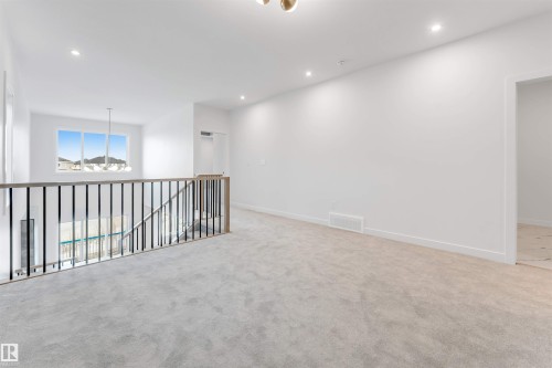 The property features an open landing with light-colored carpeting, a window providing natural light, and recessed lighting - 22 Meadowgrove Landing, Spruce Grove, AB - Indoor Photo Showing Other Room