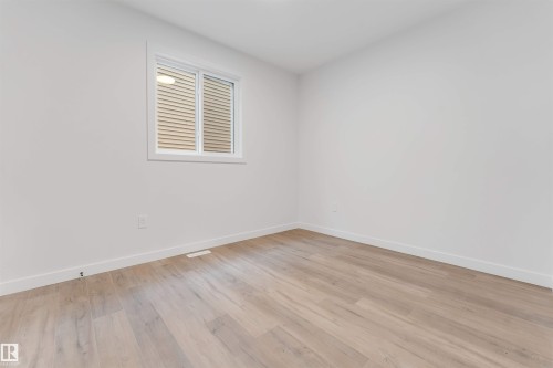 This room features light-toned wood flooring, white walls, and a window with blinds - 22 Meadowgrove Landing, Spruce Grove, AB - Indoor Photo Showing Other Room