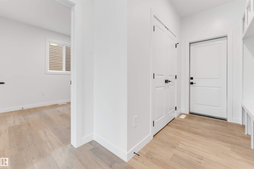 Hallway featuring light-colored flooring, white walls, and white doors with dark hardware - 22 Meadowgrove Landing, Spruce Grove, AB - Indoor Photo Showing Other Room