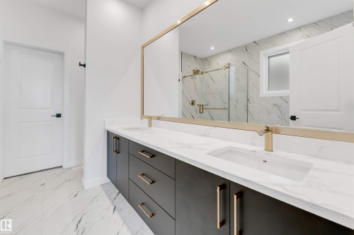 The bathroom features a double vanity with dark cabinetry, white countertops, and gold-toned hardware and faucets - 22 Meadowgrove Landing, Spruce Grove, AB - Indoor Photo Showing Bathroom