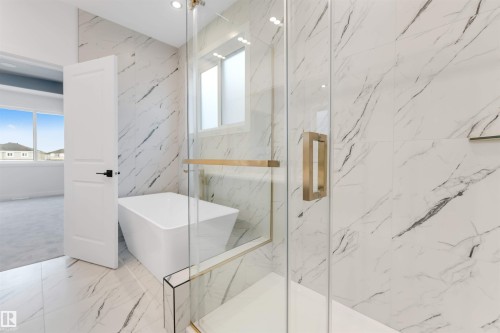 This bathroom showcases a freestanding tub and a glass-enclosed shower with gold-toned hardware - 22 Meadowgrove Landing, Spruce Grove, AB - Indoor Photo Showing Bathroom