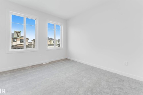 This room features two windows with white frames, white walls, and light gray carpeting - 22 Meadowgrove Landing, Spruce Grove, AB - Indoor Photo Showing Other Room