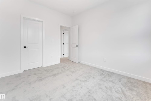 This interior space features light gray carpeting and white walls - 22 Meadowgrove Landing, Spruce Grove, AB - Indoor Photo Showing Other Room