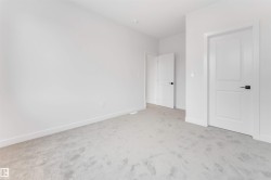 The room features light gray carpeting and white walls, offering a neutral palette - 