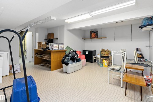 This spacious utility area features tiled flooring and overhead strip lighting, providing a functional space - 5737 189 Street, Edmonton, AB - Indoor