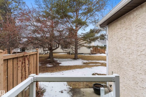The property features a private backyard with mature trees, a wooden fence, and a patio area - 5737 189 Street, Edmonton, AB - Outdoor