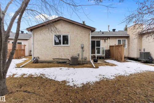 The property features an exterior with stucco siding, a brown roof, and a sliding glass door leading to a patio area - 5737 189 Street, Edmonton, AB - Outdoor With Exterior