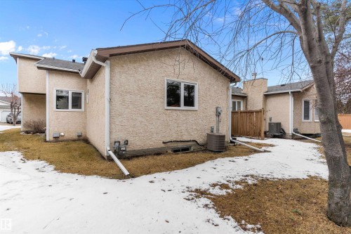 The property features an exterior with light-colored stucco siding, white window frames, and a dark shingled roof - 5737 189 Street, Edmonton, AB - Outdoor With Exterior