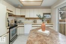 The kitchen features light-colored cabinetry, a corner sink, and a stainless steel range - 5737 189 Street, Edmonton, AB  - Indoor Photo Showing Kitchen 