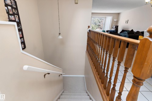 The property features a staircase with carpeted treads and a wooden balustrade, alongside a white handrail - 5737 189 Street, Edmonton, AB - Indoor Photo Showing Other Room