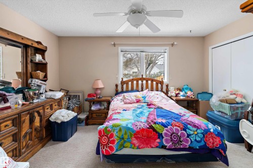 The property features a bedroom with a window, a ceiling fan, and carpeted flooring - 5737 189 Street, Edmonton, AB - Indoor Photo Showing Bedroom