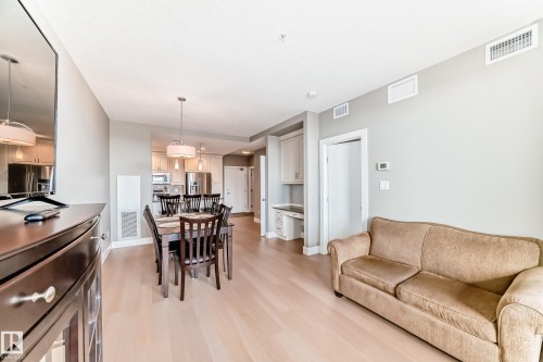 This bright main living area features light-colored flooring, recessed lighting, and a neutral color palette - 506 11080 Ellerslie Road, Edmonton, AB - Indoor Photo Showing Living Room