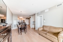 This bright main living area features light-colored flooring, recessed lighting, and a neutral color palette - 