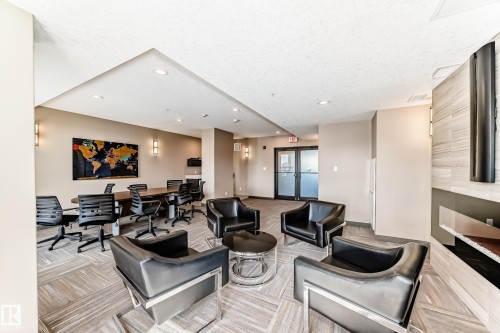 This space features recessed lighting, wall sconces, and light-toned walls - 506 11080 Ellerslie Road, Edmonton, AB - Indoor With Fireplace