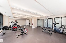 Fitness area featuring exercise equipment, ample lighting, and large windows - 