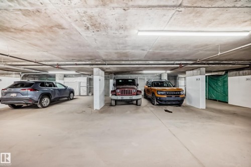Underground parking space with concrete flooring and overhead lighting - 506 11080 Ellerslie Road, Edmonton, AB - Indoor Photo Showing Garage