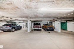 Underground parking space with concrete flooring and overhead lighting - 