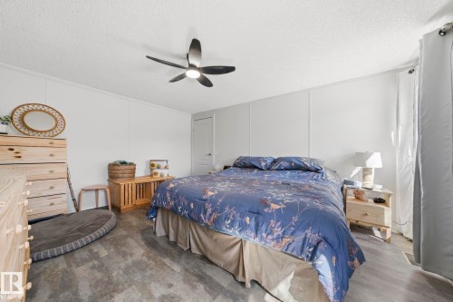 This room features light-colored walls and flooring, complemented by a ceiling fan - 66 Evergreen Park, Edmonton, AB - Indoor Photo Showing Bedroom