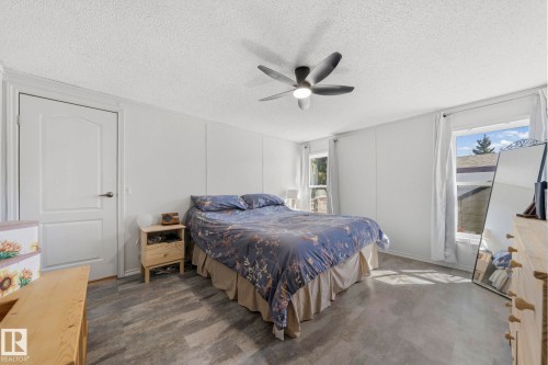 Bedroom featuring light-colored walls and flooring, a ceiling fan with integrated lighting, and two windows providing natural light - 66 Evergreen Park, Edmonton, AB - Indoor Photo Showing Bedroom