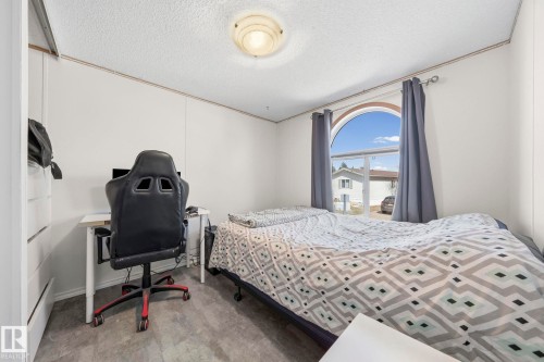 Bedroom featuring a prominent arched window, light-colored walls, and a ceiling light fixture - 66 Evergreen Park, Edmonton, AB - Indoor Photo Showing Bedroom