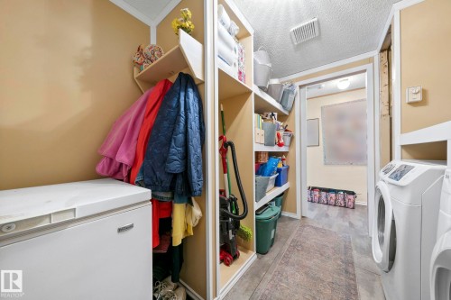 The property includes a laundry area with a washing machine and dryer, built-in shelving, and a chest freezer - 66 Evergreen Park, Edmonton, AB - Indoor Photo Showing Laundry Room