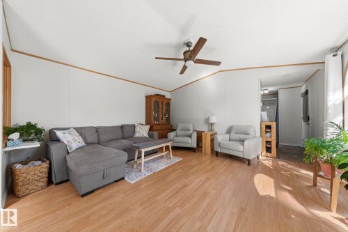 The living room features wood-look flooring, light-colored walls, and a ceiling fan - 66 Evergreen Park, Edmonton, AB - Indoor Photo Showing Other Room