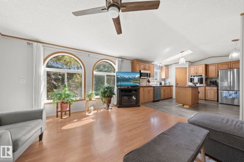 The property features a spacious open-concept living area with light-colored flooring and large arched windows - 66 Evergreen Park, Edmonton, AB - Indoor