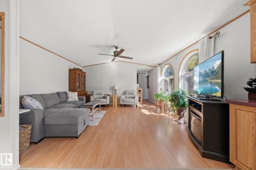 The living area features light wood flooring, white walls with wood trim, and a ceiling fan - 66 Evergreen Park, Edmonton, AB - Indoor Photo Showing Other Room