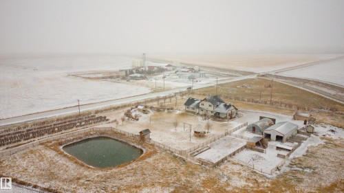 Aerial view of the property showing a large residential structure, several outbuildings, and a pond - 114039 Range Road 221, Rural Lethbridge County, AB - Outdoor With View