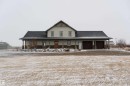 The property features a two-story structure with a covered porch and an attached garage with two bays - 114039 Range Road 221, Rural Lethbridge County, AB  - Outdoor 