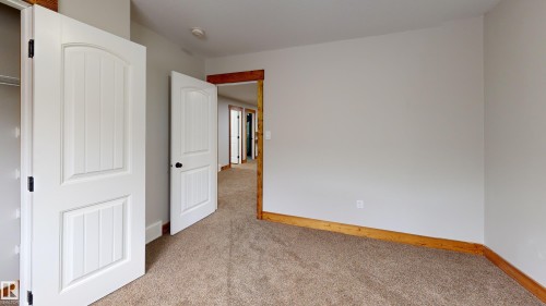 This room features soft brown carpeting, light gray walls, and natural wood trim - 114039 Range Road 221, Rural Lethbridge County, AB - Indoor Photo Showing Other Room