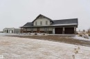 The property features a residence with a light-colored exterior, a dark roof, and a two-car garage - 114039 Range Road 221, Rural Lethbridge County, AB  - Outdoor 